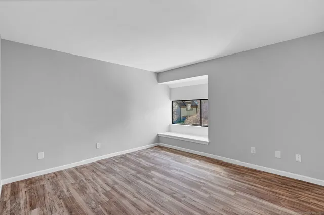 wooden floor in an empty room with a window