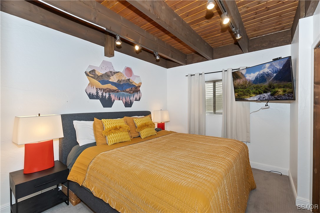42533 Moonridge Road, Unit 4 Big Bear Lake, CA 92315 - Photo 14 of 37 a bedroom with a bed and a painting on the wall