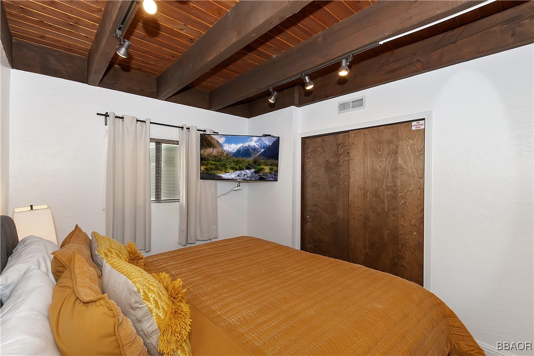 42533 Moonridge Road, Unit 4 Big Bear Lake, CA 92315 - Photo 16 of 37 a bedroom with a bed and a chandelier
