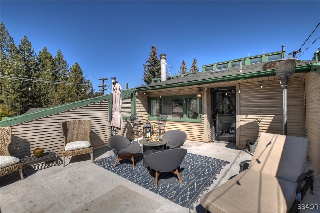 42533 Moonridge Road, Unit 4 Big Bear Lake, CA 92315 - Photo 27 of 37 a view of a patio with couches table and chairs and potted plants