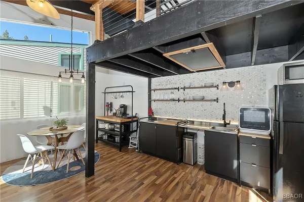 a kitchen with stainless steel appliances granite countertop a sink dishwasher and wooden cabinets with a dining table