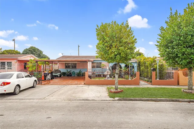 a front view of a house with a garden and tree