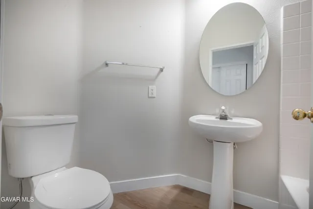an empty room with wooden floor chandelier fan and windows