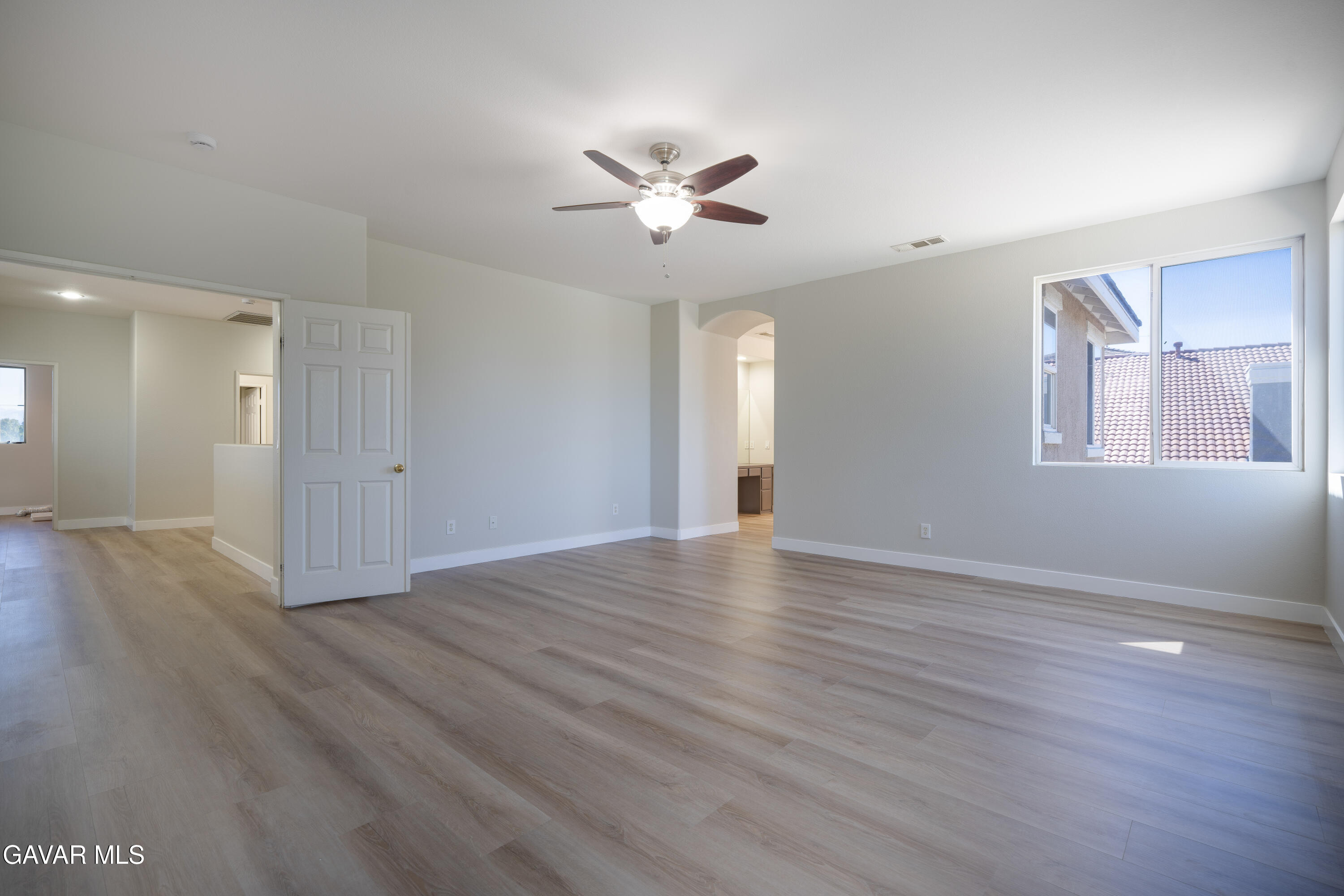 40271 Preston Road Palmdale, CA 93551 - Photo 17 of 38 a view of an empty room with wooden floor and a ceiling fan