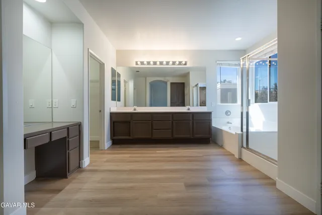a spacious bathroom with a granite countertop sink mirror and cabinets