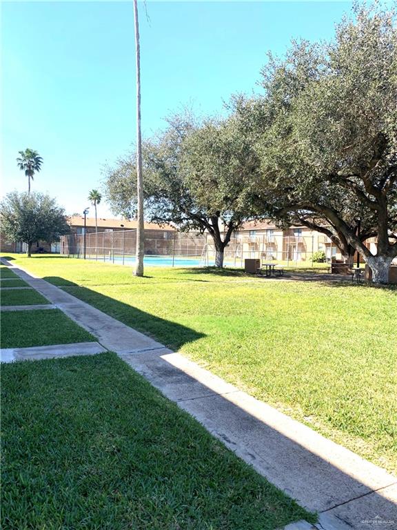 2201 South Jackson Road, Unit 35 Pharr, TX 78577 - Photo 19 of 21 a view of a swimming pool with a yard and palm trees