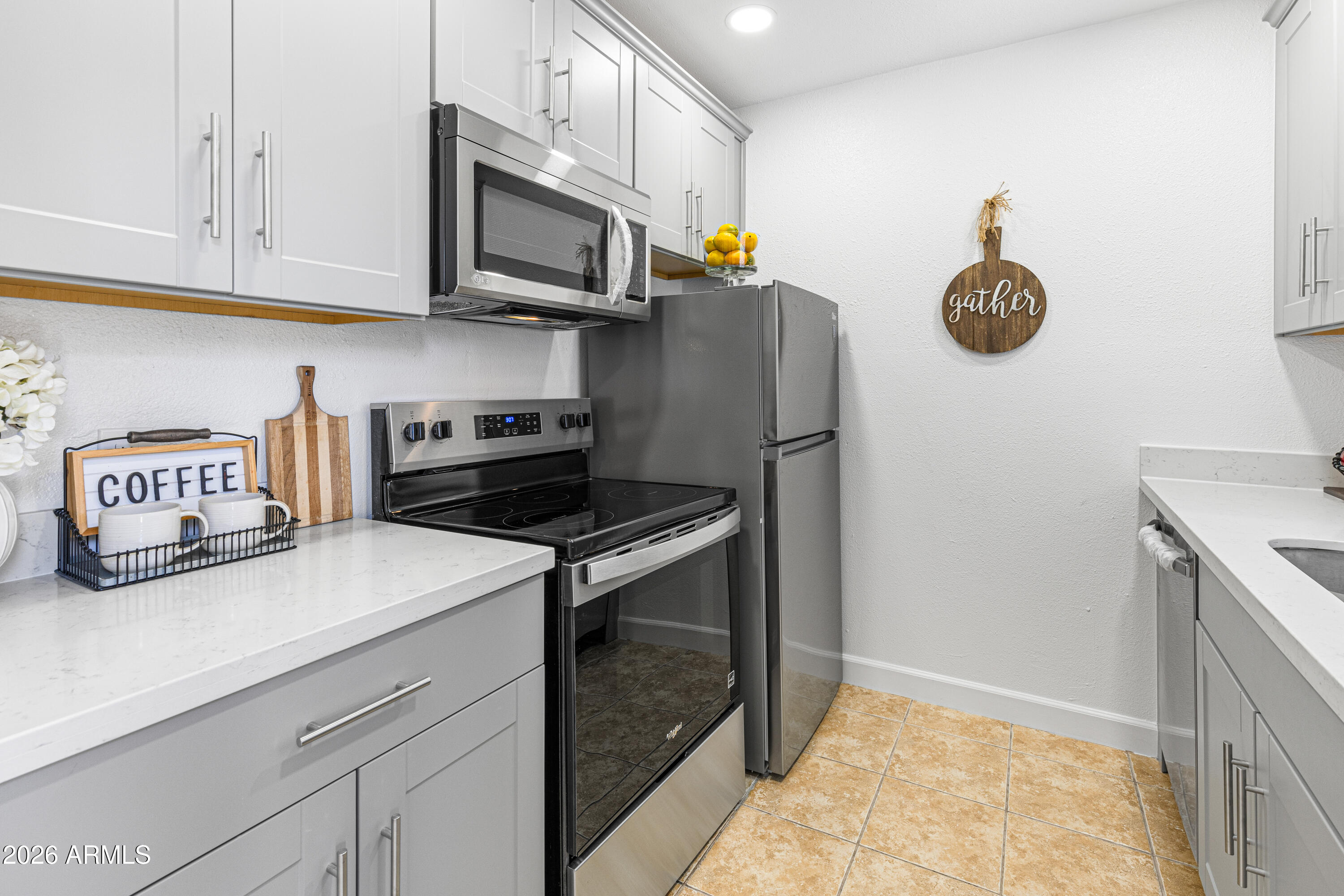 a kitchen with stainless steel appliances granite countertop a refrigerator a stove and a sink