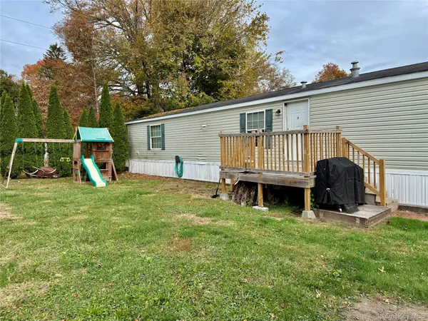 a view of a house with backyard and sitting area
