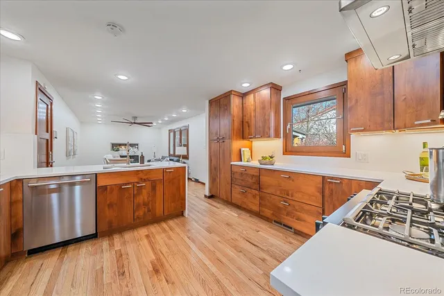 a large kitchen with stainless steel appliances granite countertop a stove a sink dishwasher and a oven with cabinets