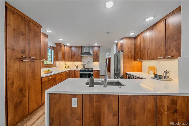 a kitchen with stainless steel appliances a sink stove and refrigerator