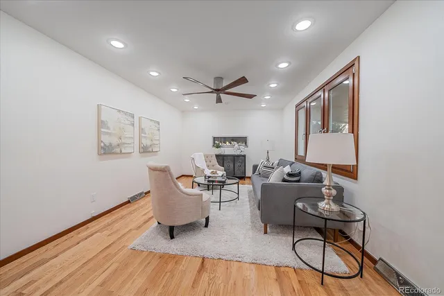 a living room with furniture a table and wooden floor