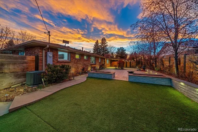 a view of a house with backyard and sitting area