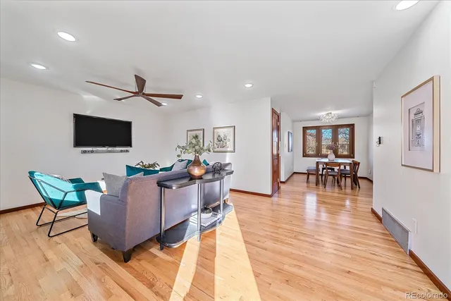 a living room with furniture a wooden floor and a flat screen tv