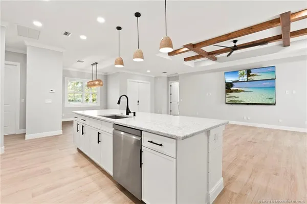 a kitchen with stainless steel appliances granite countertop a sink a window and a refrigerator