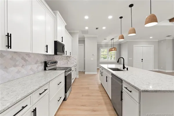 a large kitchen with stainless steel appliances granite countertop a sink a stove and a granite counter tops