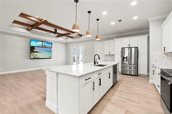 a large kitchen with stainless steel appliances kitchen island a large counter space a sink and cabinets