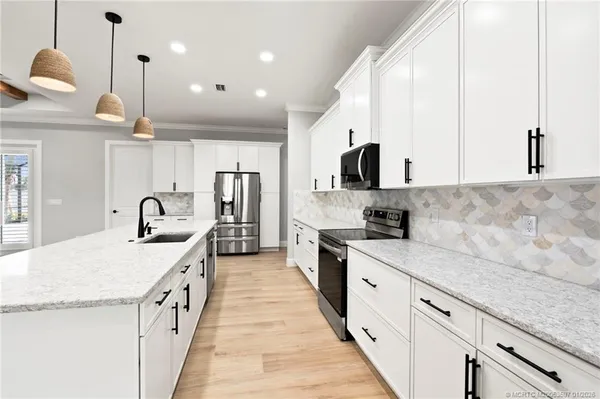 a large kitchen with stainless steel appliances kitchen island granite countertop a sink and cabinets