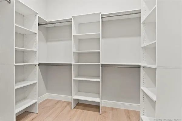 a view of walk in closet with empty racks