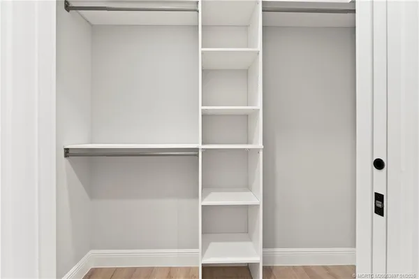 a view of walk in closet with empty racks
