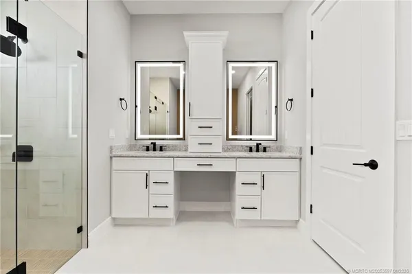 a bathroom with double vanity sinks and a mirror