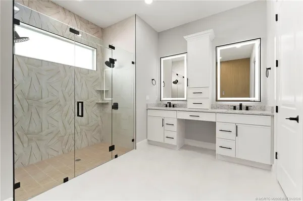 a bathroom with a double vanity sink mirror and shower
