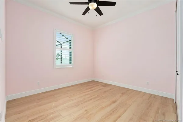 an empty room with a window and a ceiling fan