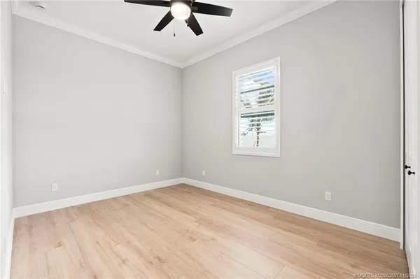 an empty room with a window and ceiling fan