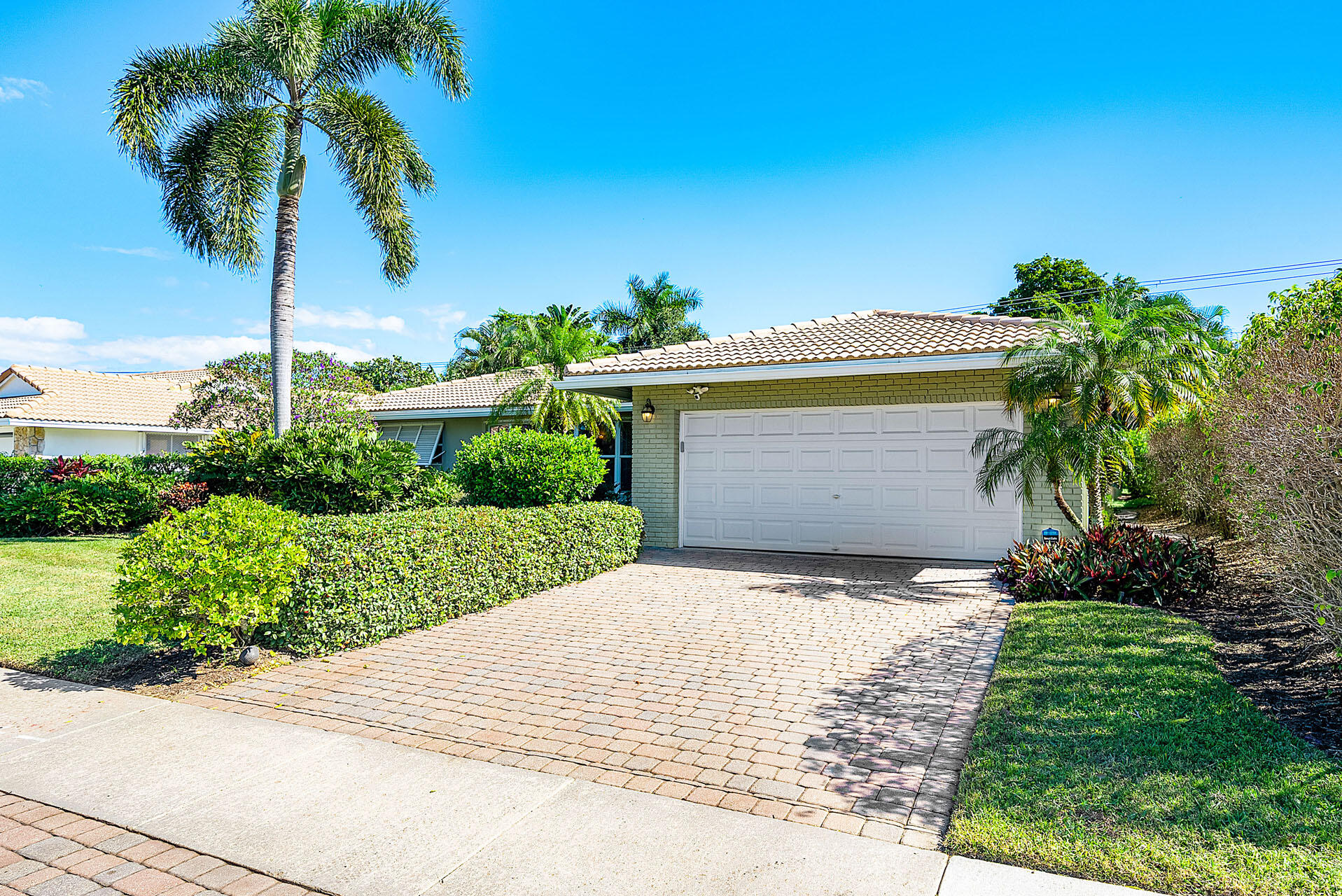 220 Southwest 9th Avenue Boca Raton, FL 33486 - Photo 5 of 42 a front view of a house with a yard and palm trees