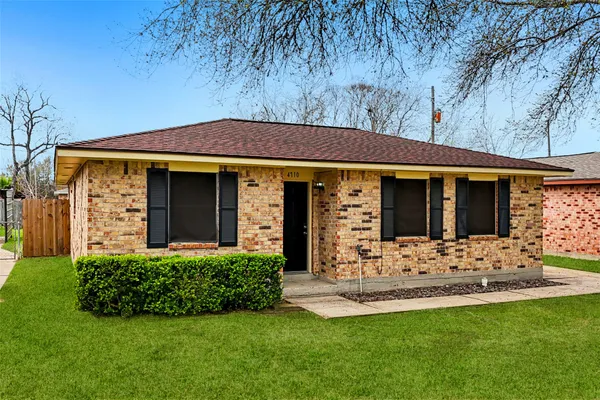 a view of a house with table and chairs in a yard