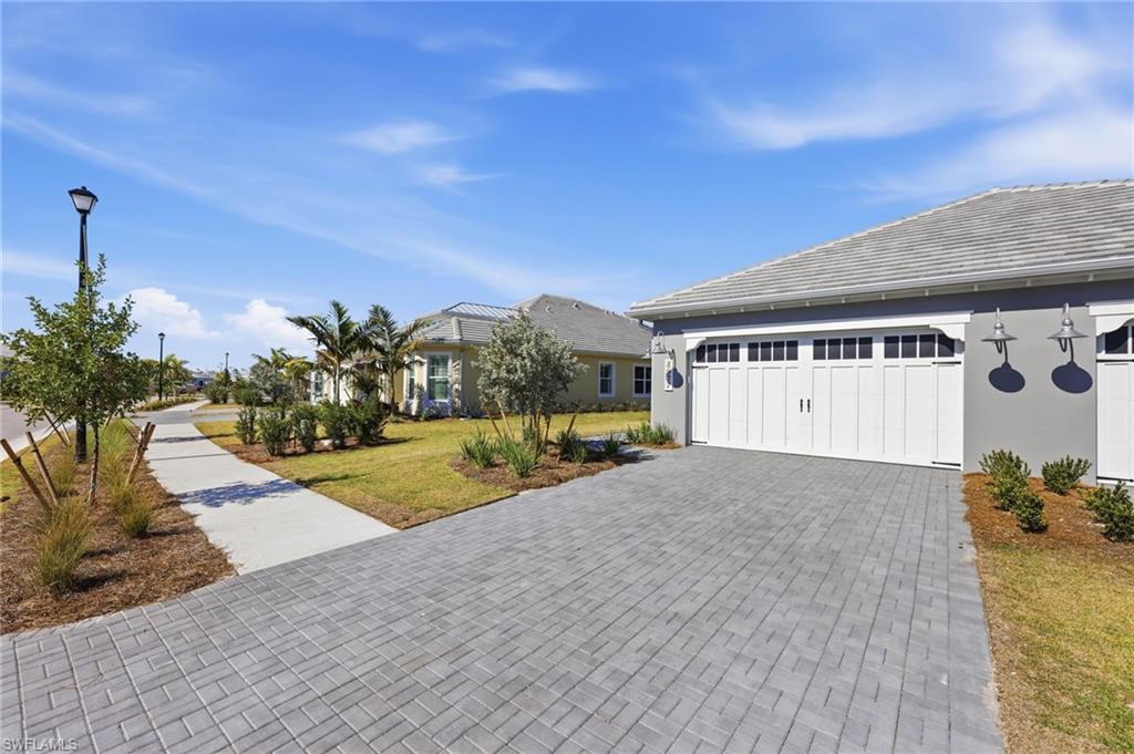 8937 Calypso Court Naples, FL 34113 - Photo 2 of 43 a view of a house with a yard and potted plants