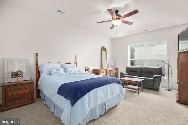 a bedroom with a bed and a flat tv screen on dresser