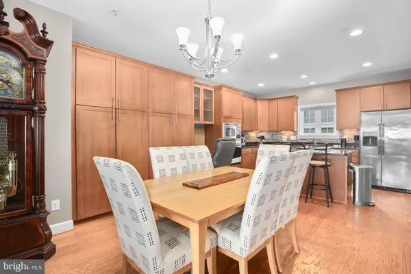 a dining hall with stainless steel appliances granite countertop a stove top oven a dining table and chairs