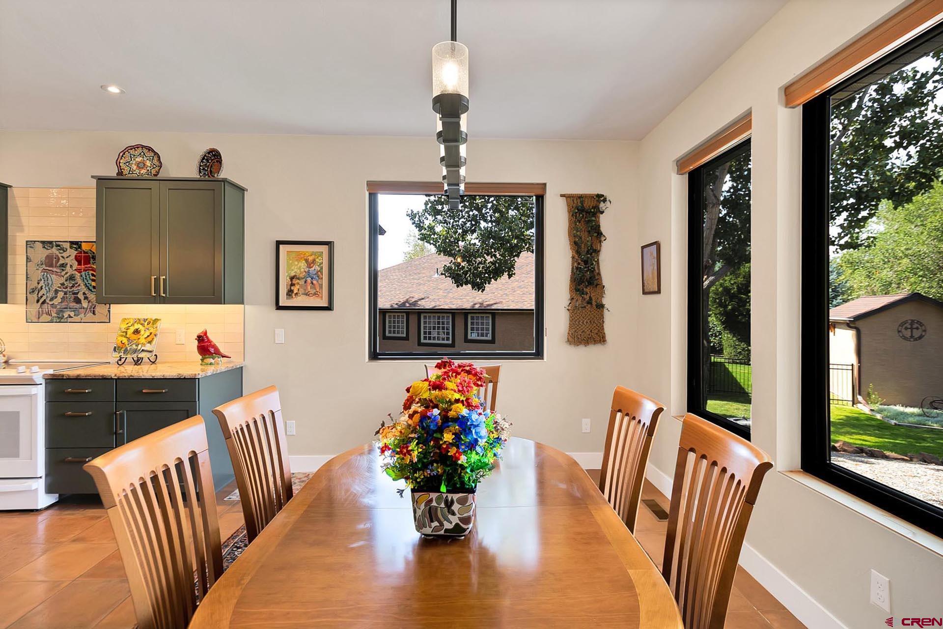 1470 Southeast Stonebridge Drive Cedaredge, CO 81413 - Photo 11 of 42 a living room with furniture dining table and a floor to ceiling window