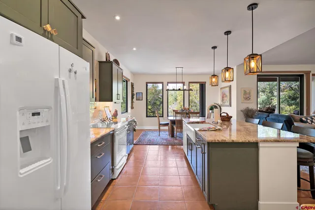 a large kitchen with stainless steel appliances lots of counter space windows and a chandelier