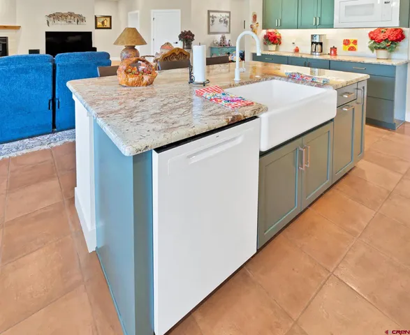 a kitchen with a sink a stove and wooden floor