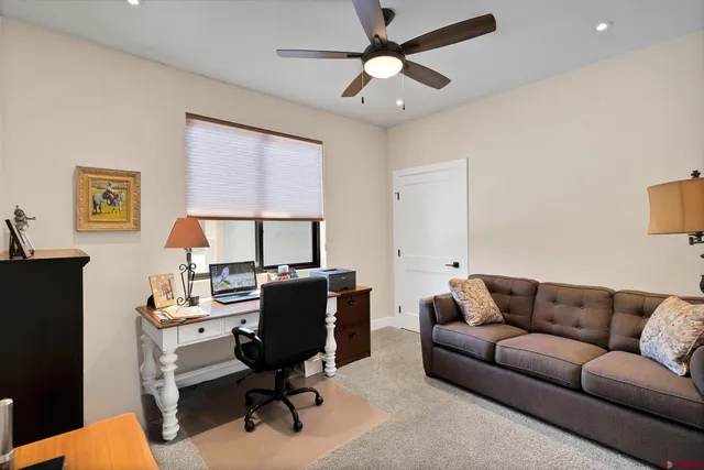 a livingroom with workspace couch and a window