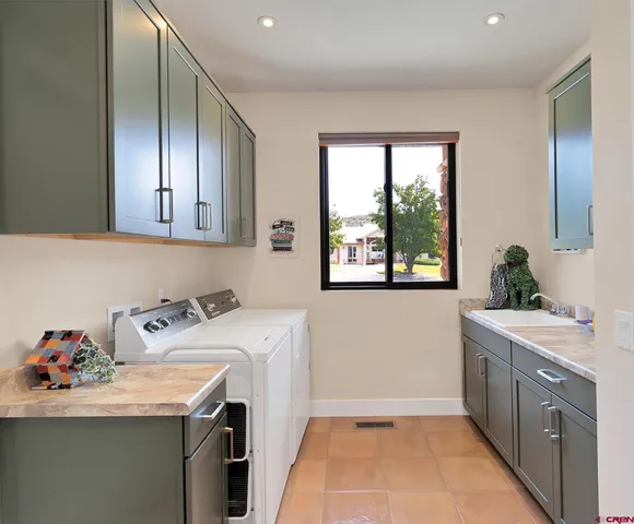 a utility room with sink dryer and washer