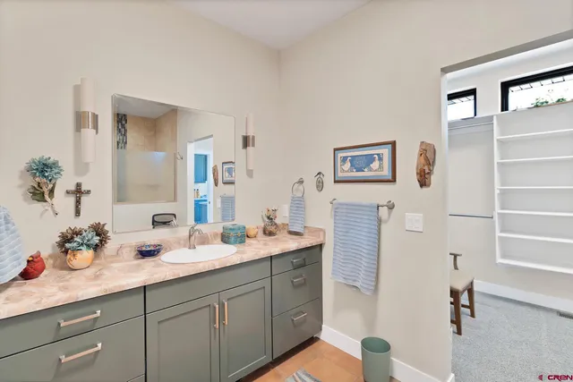 a spacious bathroom with a double vanity sink a mirror and shower