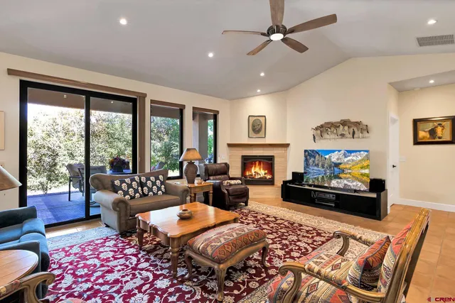 a living room with furniture fireplace and a large window