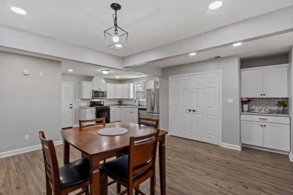 a view of a dining room and a kitchen with a table chairs