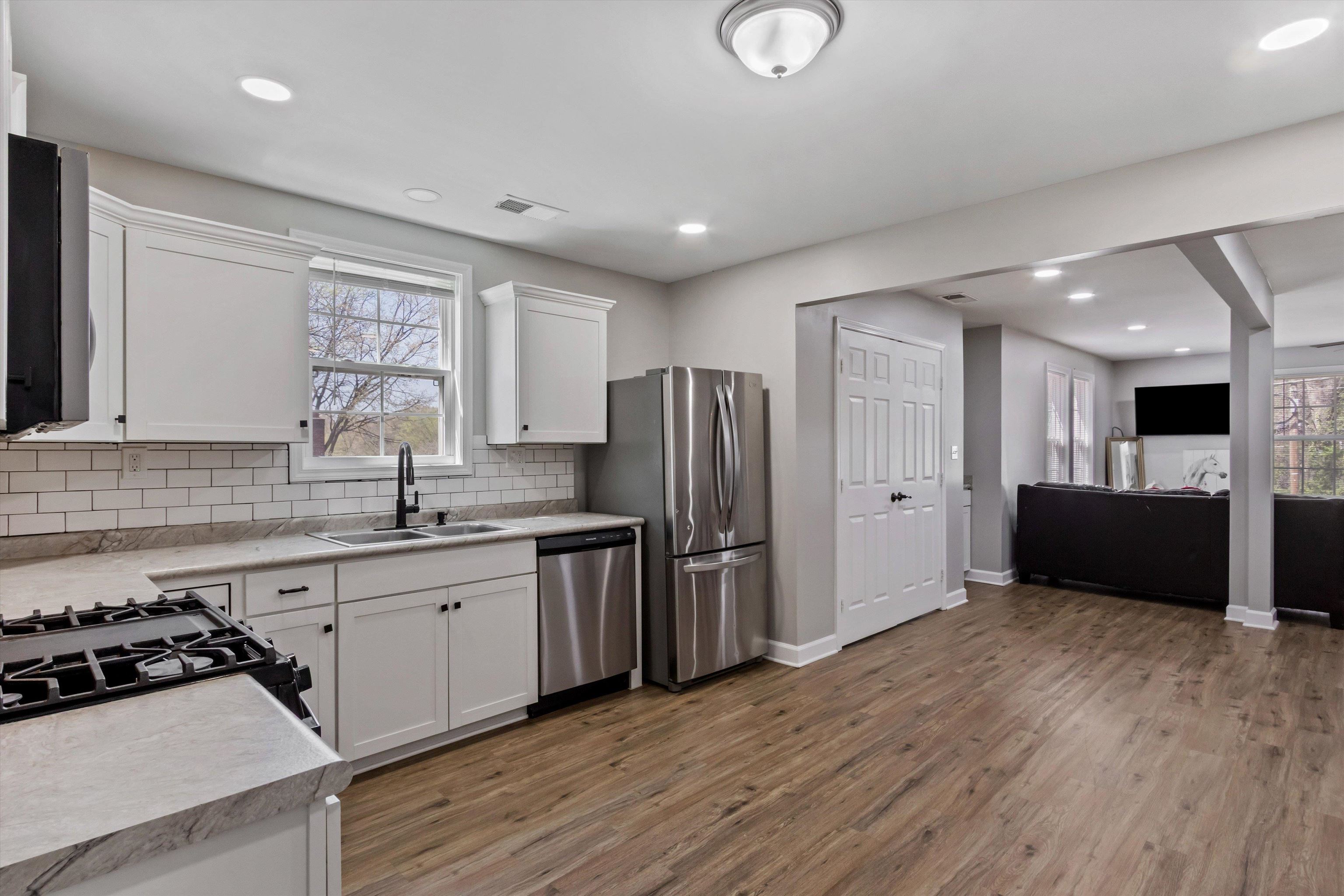 1217 Carlton Road Memphis, TN 38106 - Photo 31 of 32 Kitchen with light countertops, white cabinets, stainless steel appliances, open floor plan, and dark wood-type flooring