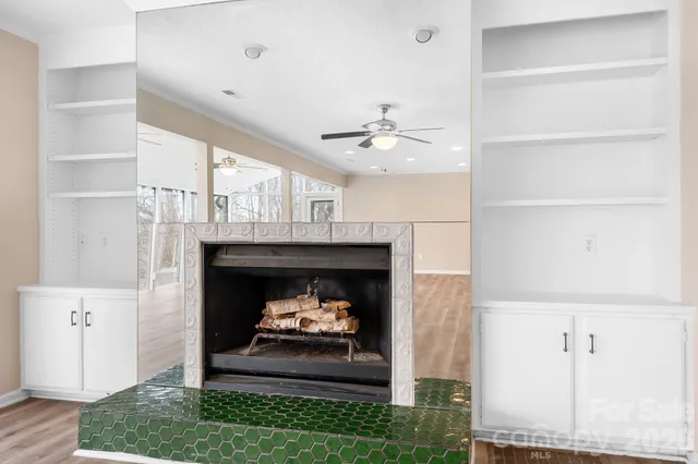 a living room with a fireplace and a ceiling fan