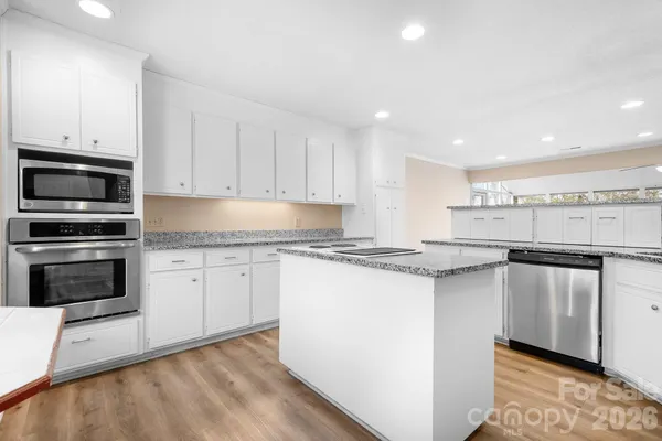 a kitchen with stainless steel appliances granite countertop a stove a sink and a microwave