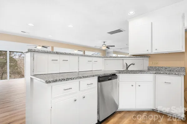 a kitchen with granite countertop white cabinets and white appliances