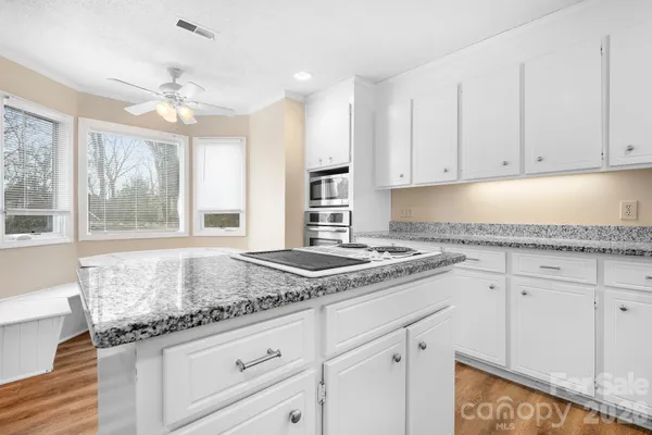 a kitchen with granite countertop cabinets stainless steel appliances and a window