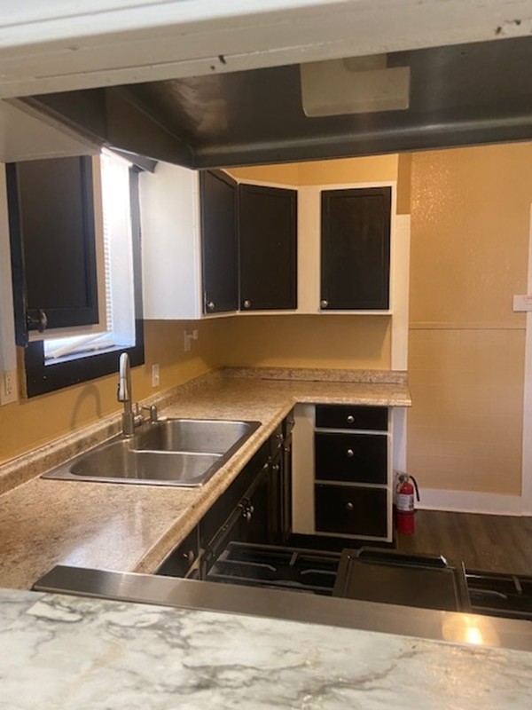 214 South Hackberry Avenue Luling, TX 78648 - Photo 6 of 22 Kitchen with light countertops, dark cabinetry, and stainless steel gas cooktop