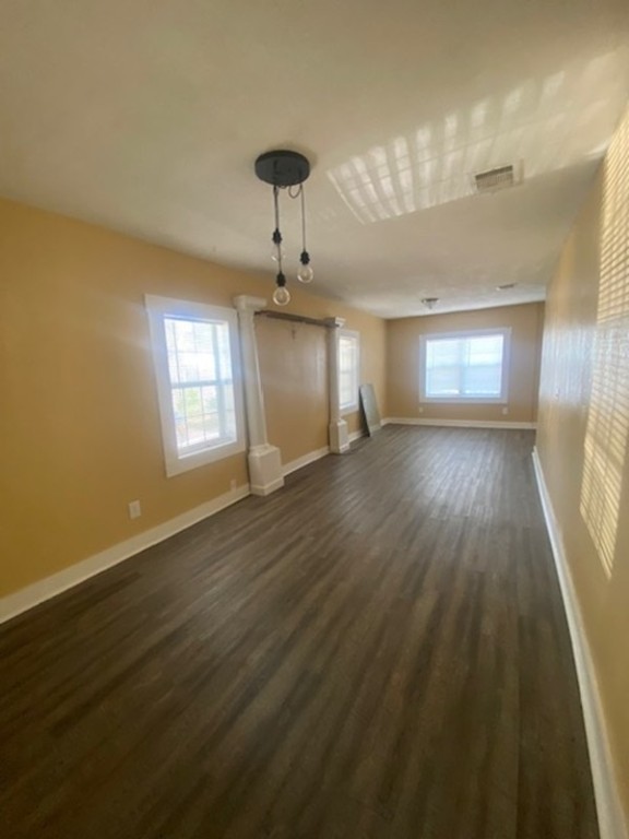 214 South Hackberry Avenue Luling, TX 78648 - Photo 10 of 22 an empty room with wooden floor chandelier and windows