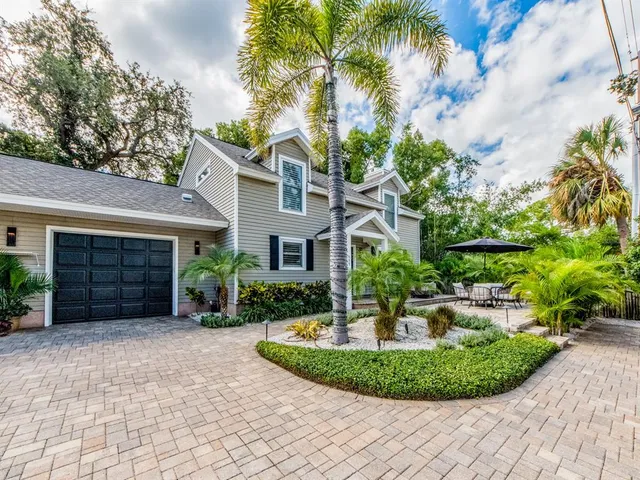 a front view of a house with a yard and potted plants