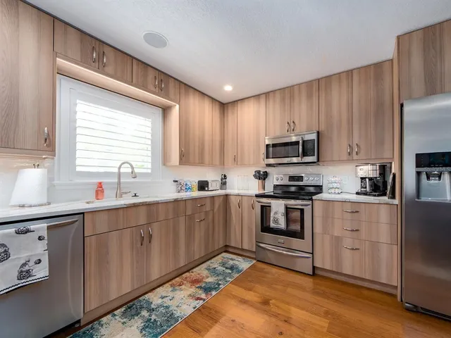 a kitchen with stainless steel appliances granite countertop a stove sink microwave and refrigerator