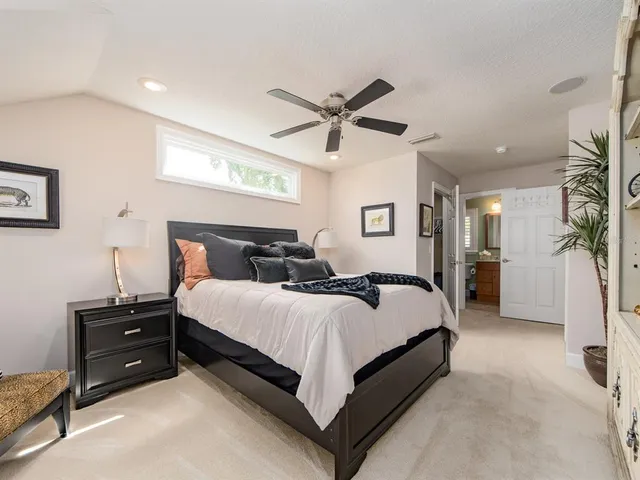 a spacious bedroom with a bed and ceiling fan